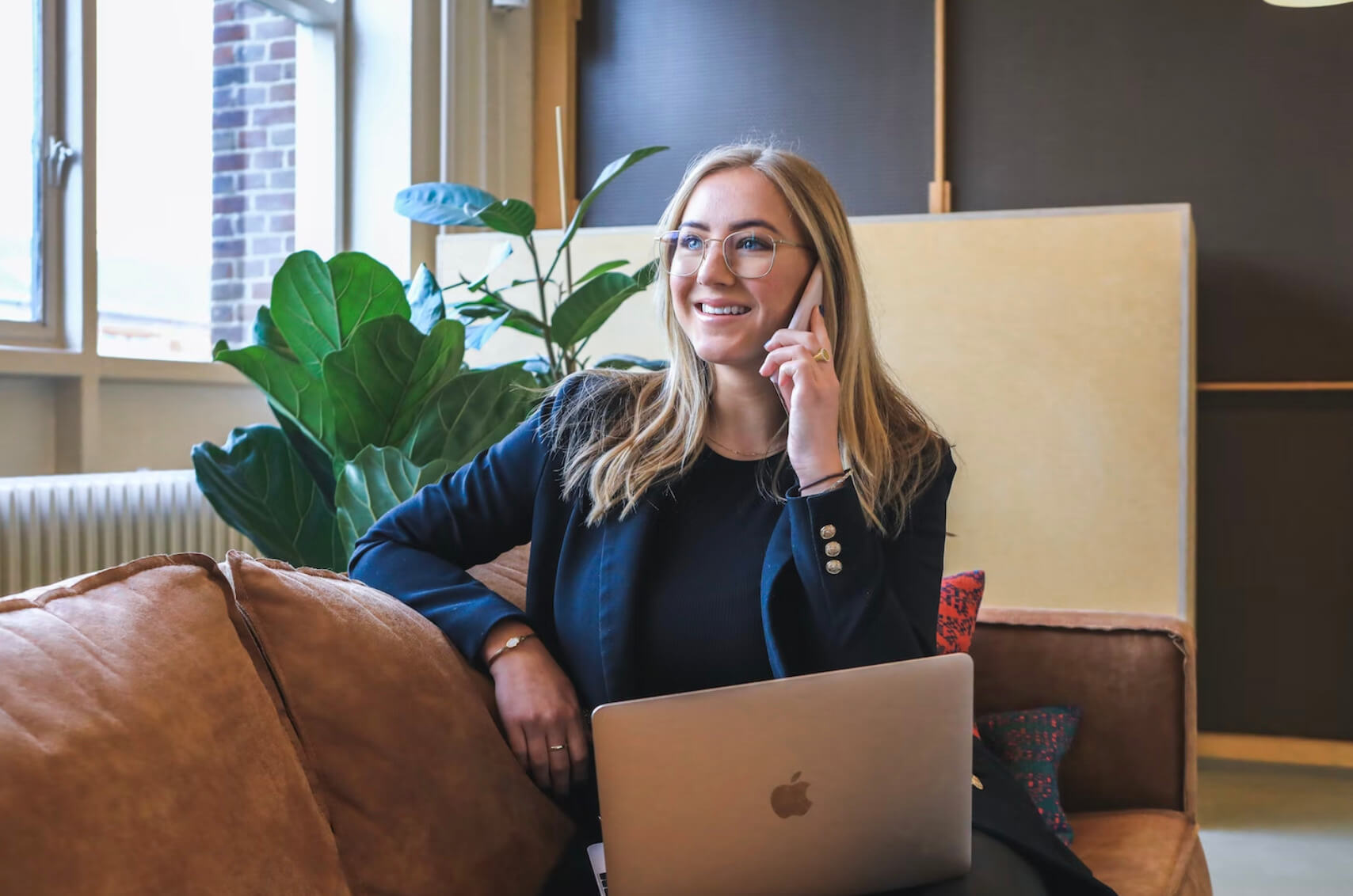 Young professional girl calling with laptop on her lap