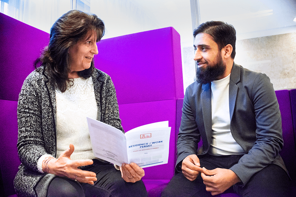 Woman and man discussing a folder titled 'Residence/Work permit'